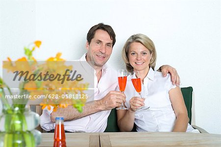 Couple à la maison tinter les verres de champagne, Munich, Bavière, Allemagne
