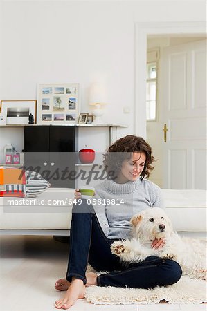 Woman petting dog in living room
