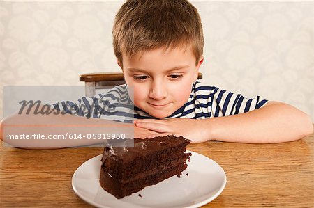 Boy looking at Stück Schokolade Kuchen
