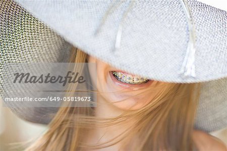 Smiling girl in braces wearing sunhat