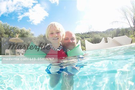 Father and son playing in pool