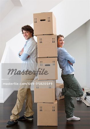 Couple with stack of cardboard boxes