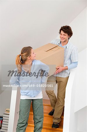 Couple carrying cardboard box