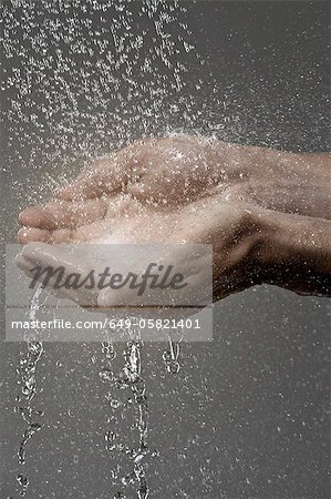 Woman catching water in cupped hands