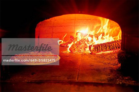 Pizza baking in wood burning oven