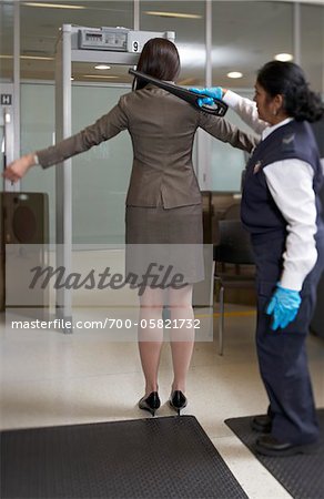 Femme d'affaires passant par vérification de la sécurité à l'aéroport Femme d'affaires passant par vérification de la sécurité à l'aéroport