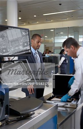 Garde de sécurité vérifiant porte-documents les hommes d'affaires dans l'aéroport Garde de sécurité vérifiant porte-documents les hommes d'affaires dans l'aéroport