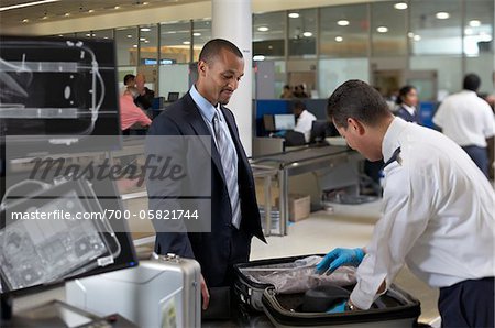 Wachmann, die Überprüfung der Geschäftsmann Koffer im Flughafen