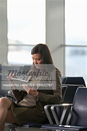 Femme d'affaires à l'aide de Tablet PC dans l'aéroport