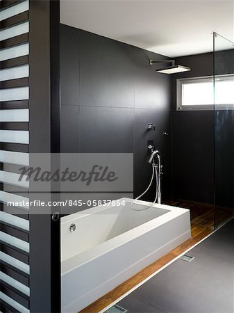 Moderne minimal Badezimmer mit dunklen Wänden, Badewanne und High-Level-Fenster