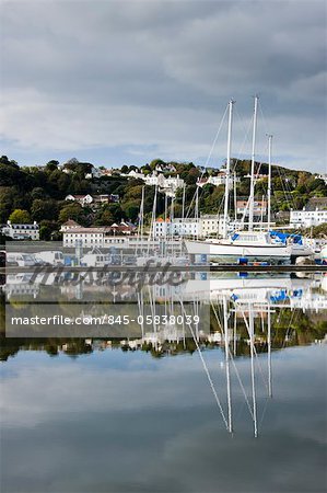 St Peter Port and harbour side boats stored on dry dock reflected in a model boat pond in Guernsey, Channel Islands, UK