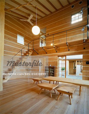 Holztisch und Stühle im Zentrum von Holz getäfelten Zimmer mit hoher Decke und Treppe zum Obergeschoss