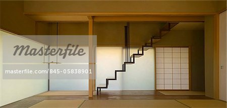 Traditionally Japanese sparsely furnished room with staircase