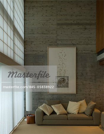 Double height living room with artwork and frosted glass