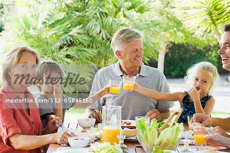 Multi-generation family enjoying meal outdoors