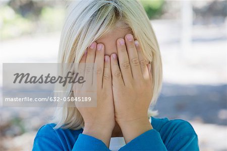 Boy covering face with hands