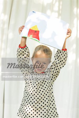 Little girl showing off drawing, portrait