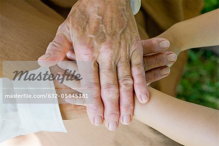 Hands of senior woman and little girl stacking