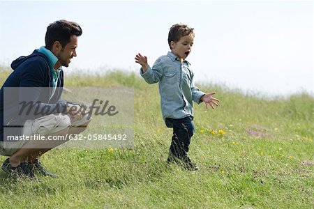 Vater und Sohn spielen auf Wiese