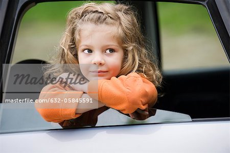 Little girl leaning out of car window, portrait
