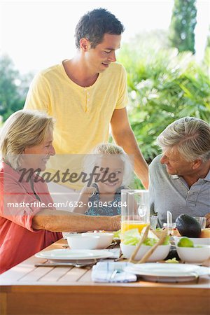 Multi-generation family having meal outdoors