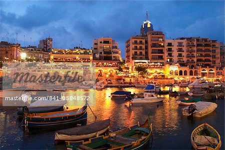 Dans l'ensemble de la baie de Spinola en soirée avec des restaurants, de St. Julians, Malte, Méditerranée, Europe Dans l'ensemble de la baie de Spinola en soirée avec des restaurants, de St. Julians, Malte, Méditerranée, Europe