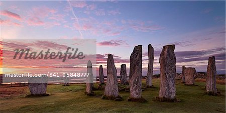 Fiery nuages au-dessus les menhirs de Calanais au lever du soleil à l'automne, l'île de Lewis, Hébrides extérieures en Écosse, Royaume-Uni, Europe