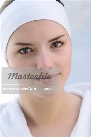 Woman with headband, lookintg at the camera, close up (studio)