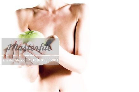 Femme nue tenant une pomme verte, bouchent (studio)