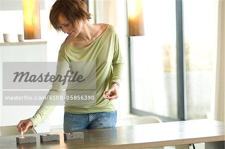 Young woman lighting candles