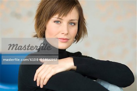 Young woman sitting on the floor, looking at the camera Young woman sitting on the floor, looking at the camera