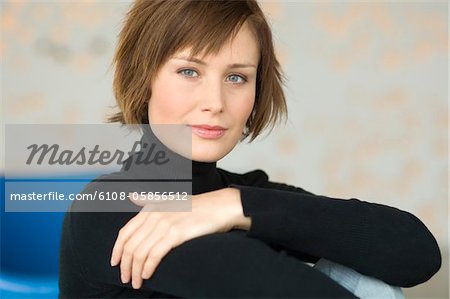 Jeune femme assise sur le plancher, en regardant la caméra