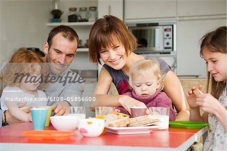 Couple and 3 children having breakfast