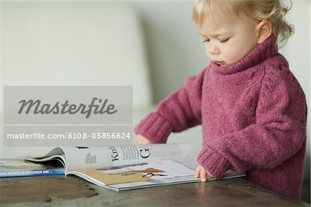 Little boy reading a magazine