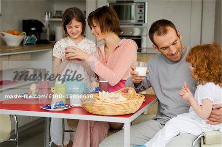 Couple and 2 little girls at breakfast table