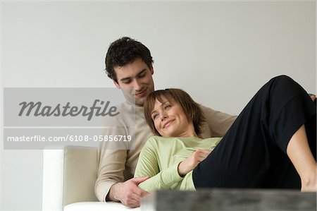 Couple souriant, couché sur un sofa