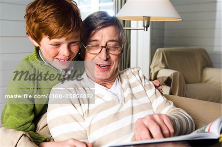 Senior man and boy reading a book