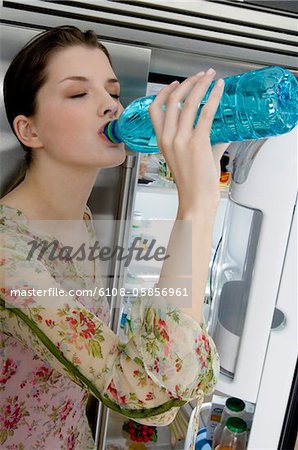 Jeune femme potable l'eau de bouteille