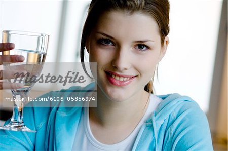 Portrait of a young woman holding a glass of water