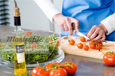 Woman making a salad, chopping tomatoes, close-up Woman making a salad, chopping tomatoes, close-up