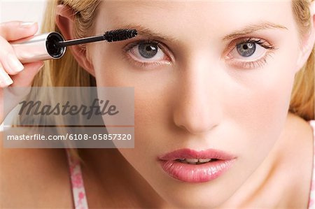 Porträt einer jungen Frau Konfektion mit Mascara, Indoor (Studio)