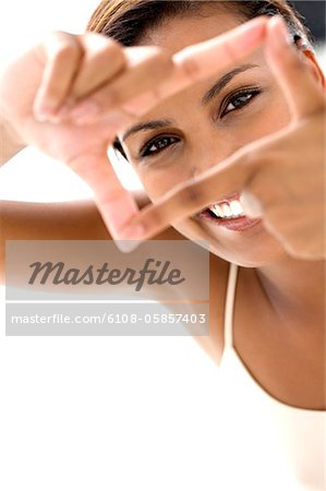Porträt einer jungen lächelnde Frau machen einen Rahmen mit den Fingern