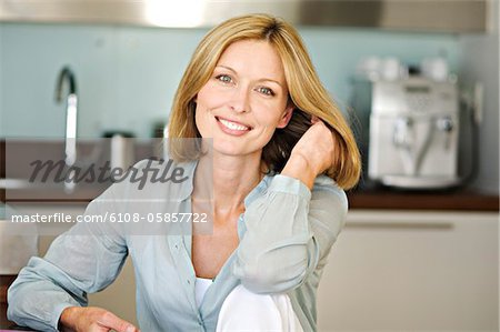 Femme souriante avec la main dans les cheveux