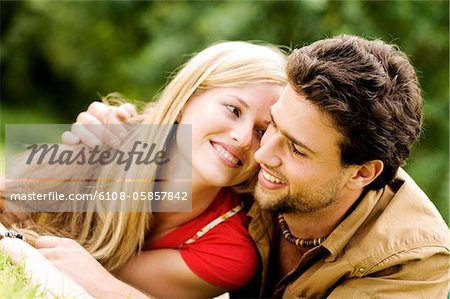 Portrait d'un jeune souriant couple embrassant, en plein air
