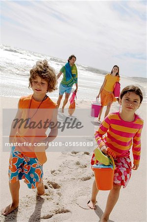 Eltern und zwei Kinder Wandern am Strand, im freien