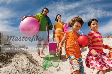 Parents and two children walking on the beach, outdoors