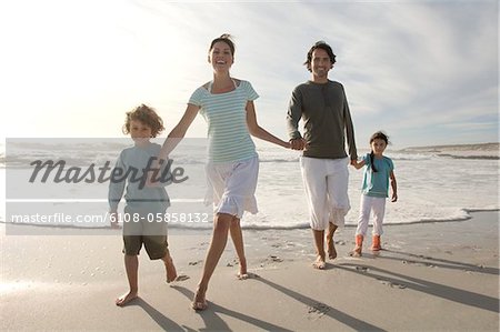 Eltern und zwei Kinder Wandern am Strand, im freien