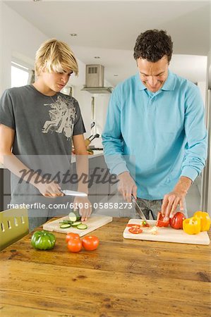 Faher and teenager cooking, indoors