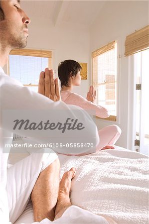 Young couple in yoga attitude, indoors