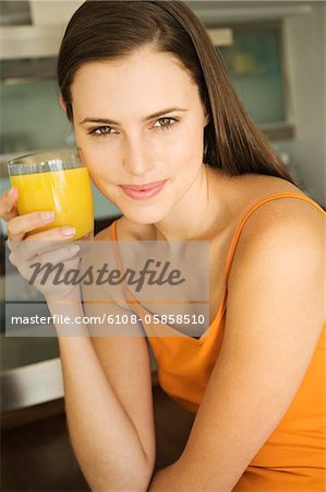 Young woman holding glass of orange juice